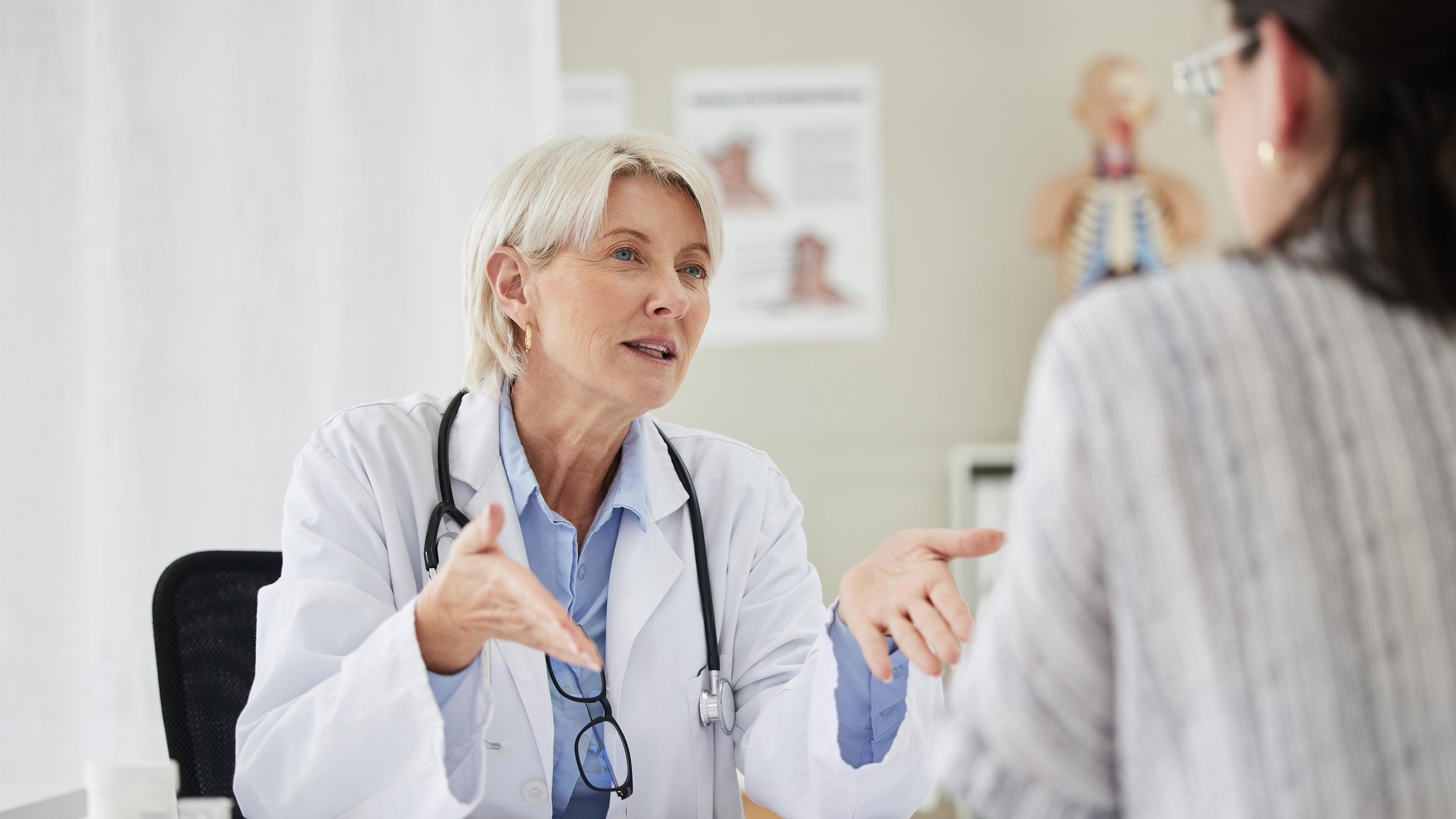 Das Foto zeigt eine Ärztin, die im Gespräch mit einer Patientin ist